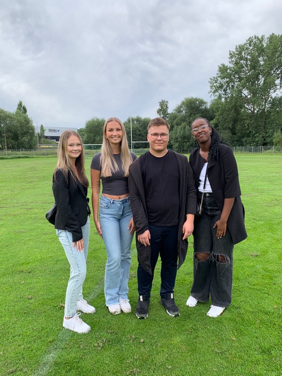 fyra elever som ler mot kameran.