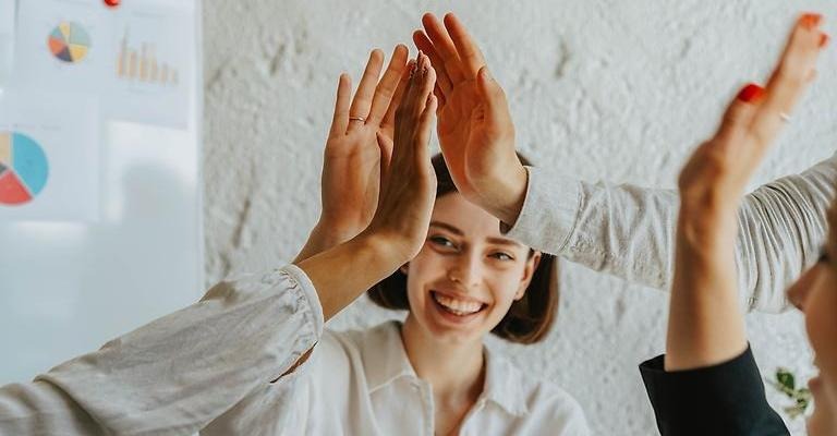fem händer som gör en high-five.