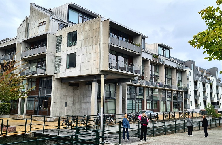 Fyra elever framför grå byggnad.