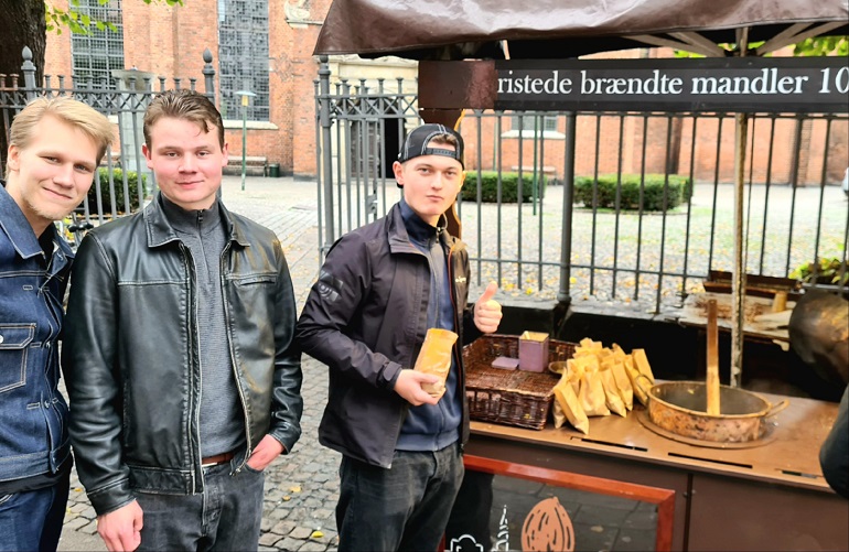 Tre elever som köper brända mandlar.